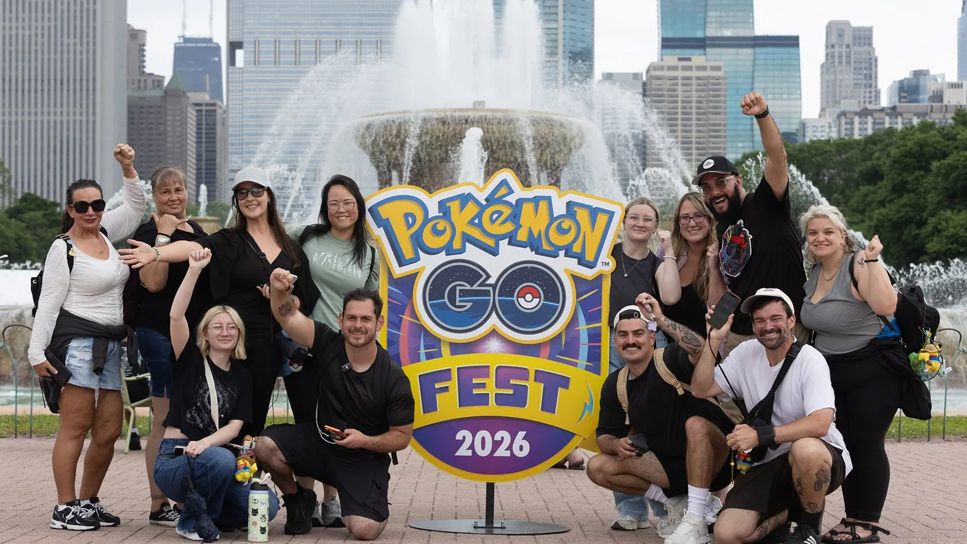 A group of Pokémon GO players cheering in front of the Pokémon GO Fest 2026 sign at Buckingham Fountain in Chicago